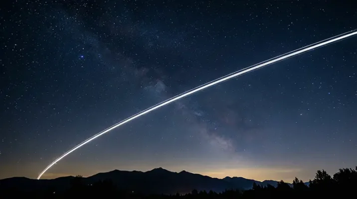 Long exposure photograph of a Starlink satellite train in the night sky highlighting the SpaceX satellite vulnerability to area-effect weapons.